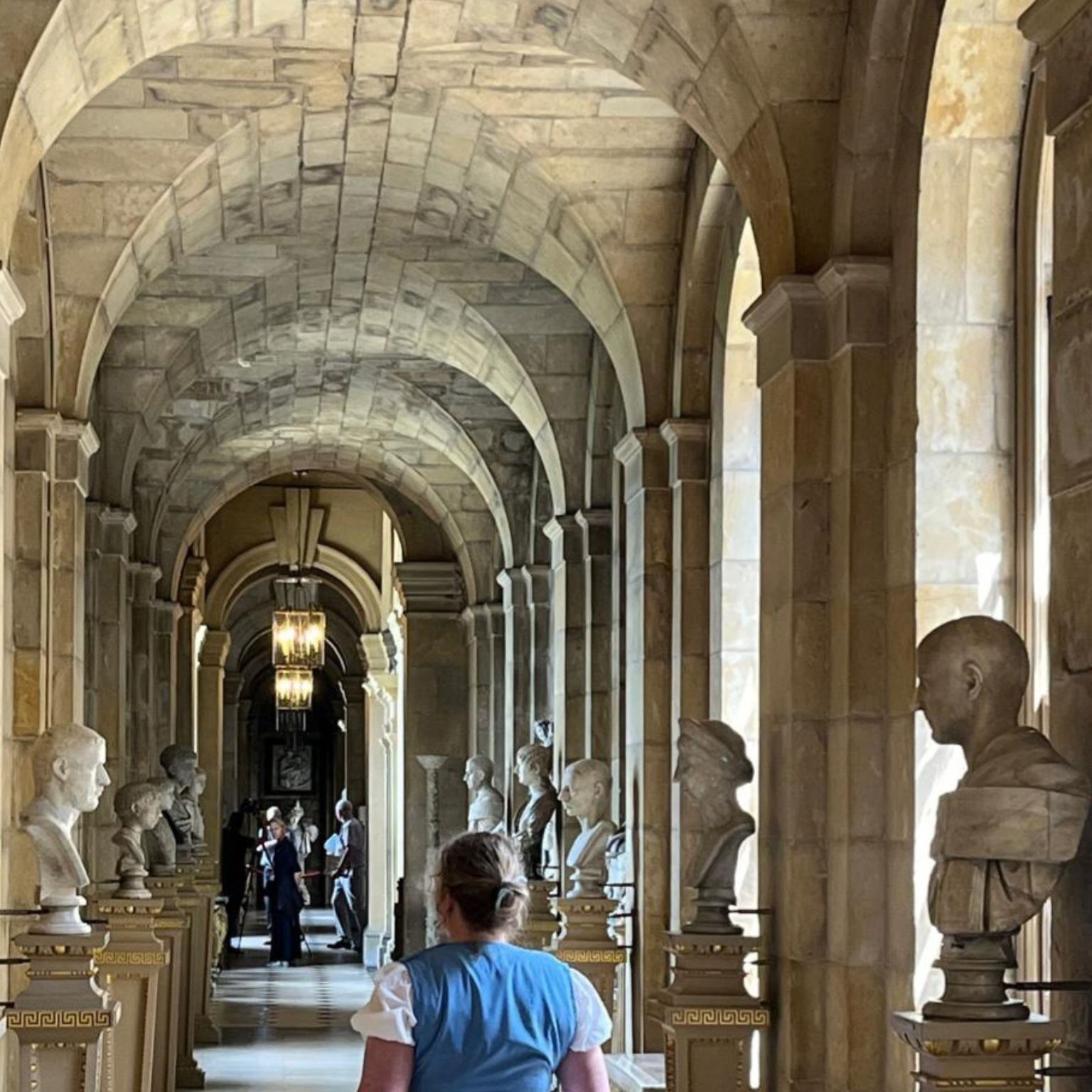 Heritage website overhaul - visitor walking down hall of statues at Castle Howard